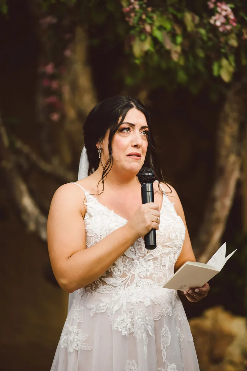 A bride reading her vows from her vow book on the wedding day.